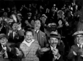 a black and white photo of a crowd of people standing in a stadium .