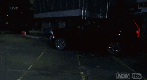 a black suv is parked in a parking lot with the aew logo on the bottom left
