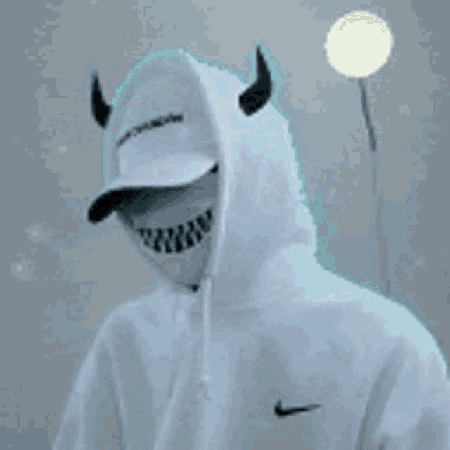a close up of a person wearing a white hoodie with shark teeth .