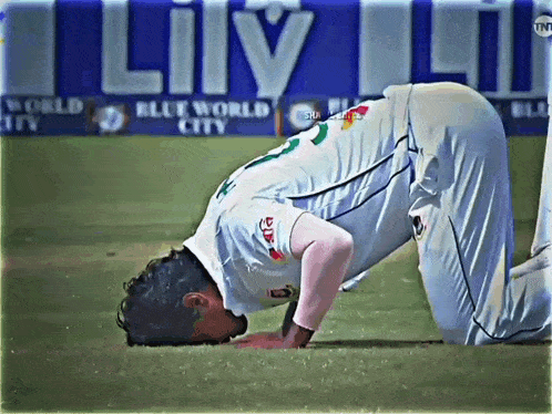 a soccer player kneeling down with his head on his knees in front of a blue world city banner