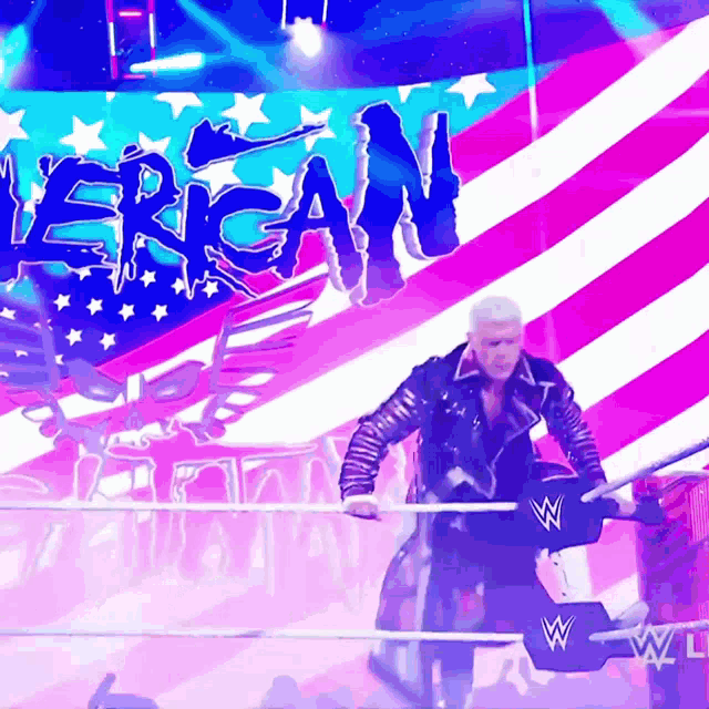 a man in a wrestling ring with the word american on the wall behind him