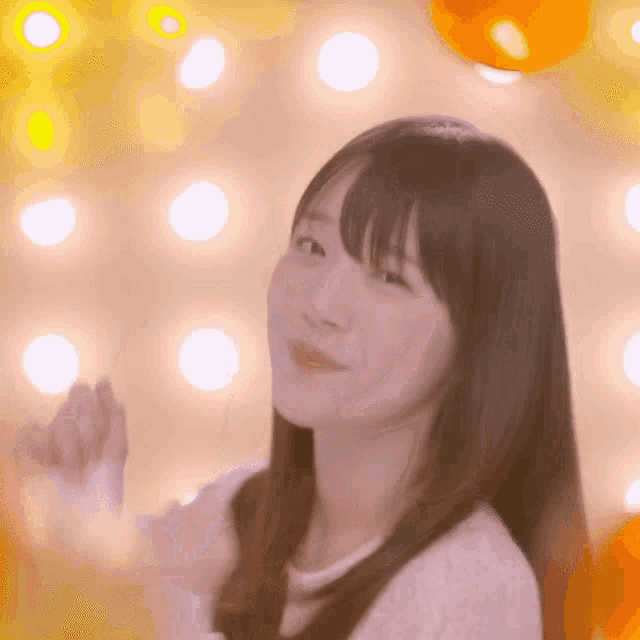 a woman in a white sweater looks at the camera