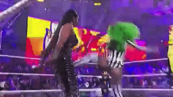 two women are wrestling in a ring while a referee watches .