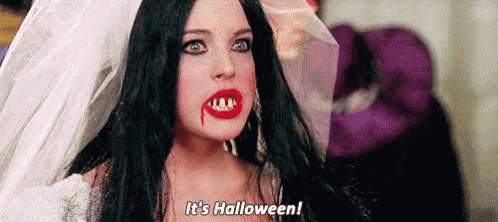 a woman in a vampire costume with blood on her lips is saying `` it 's halloween '' .