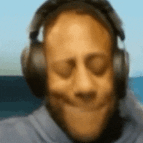 a blurry picture of a man wearing headphones and making a face