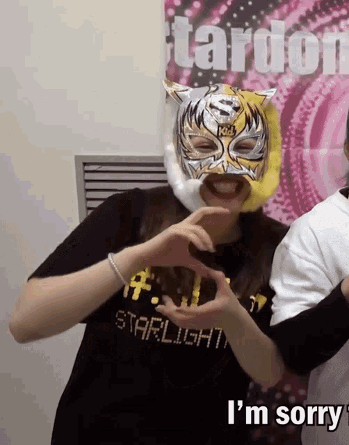 a woman wearing a tiger mask is making a heart with her hands