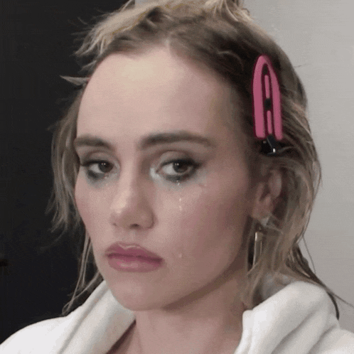 a woman with a clip in her hair has a tear running down her cheek