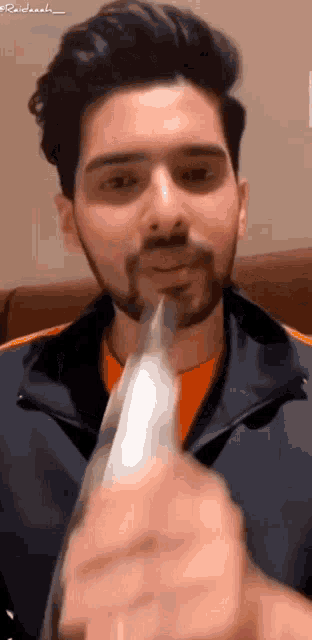 a man with a beard is holding a knife in front of his mouth