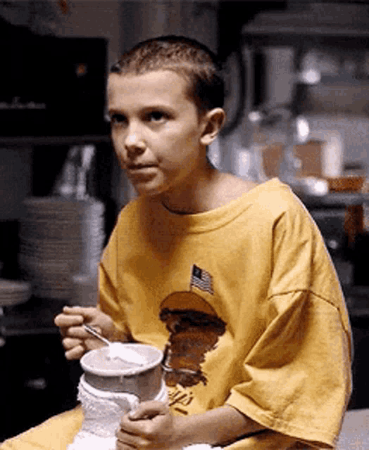 a young boy wearing a yellow t-shirt with a hamburger on it