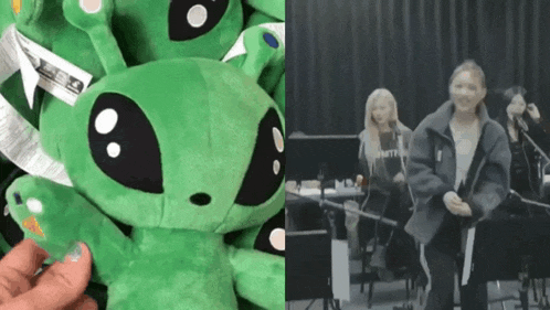 a person is holding a stuffed green alien next to a woman holding a guitar