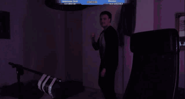 a man is dancing in front of a screen that says ' consfera ' on it