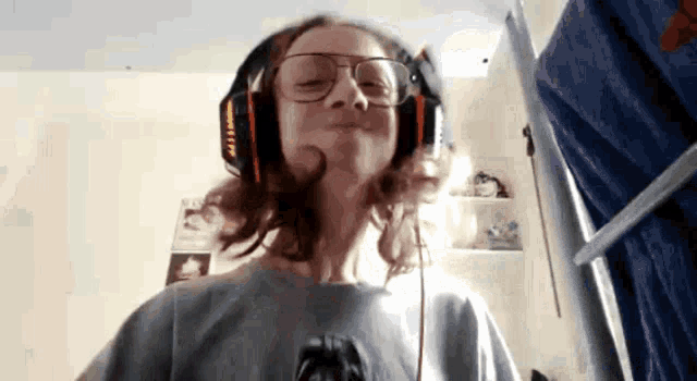 a young girl wearing glasses and headphones looks at the camera
