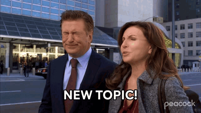 a man and a woman are standing in front of a building and the woman says " new topic "