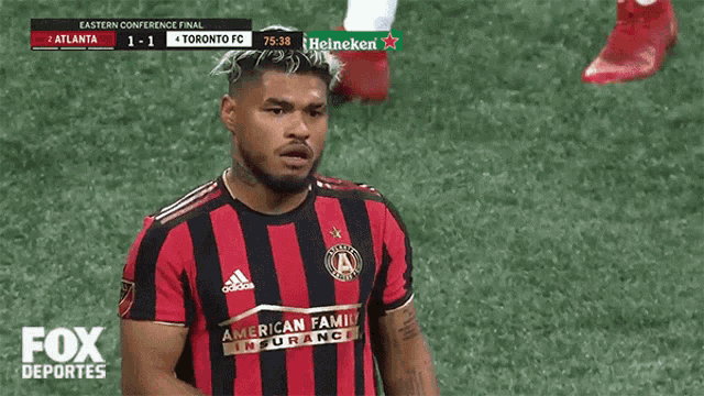 a toronto fc soccer player stands on the field