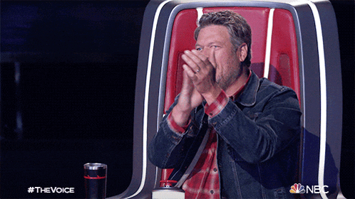 a man in a denim jacket is sitting in a chair with his hands on his face and the words #thevoice on the bottom
