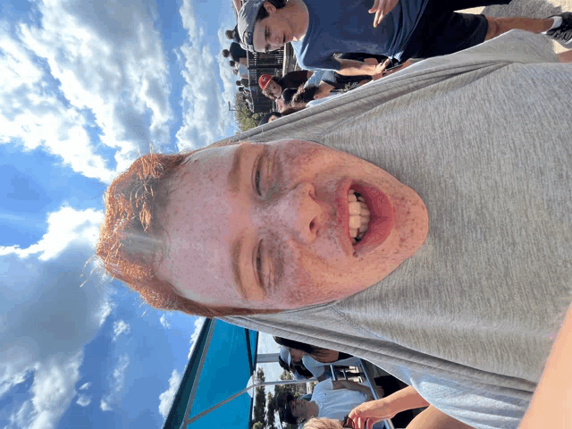 a young man with red hair and freckles is smiling