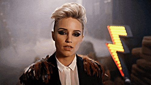 a woman in a feathered jacket is standing in front of a lightning bolt