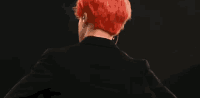 the back of a man with red hair wearing a black suit