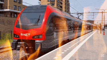 a red r-net train is pulling into a train station