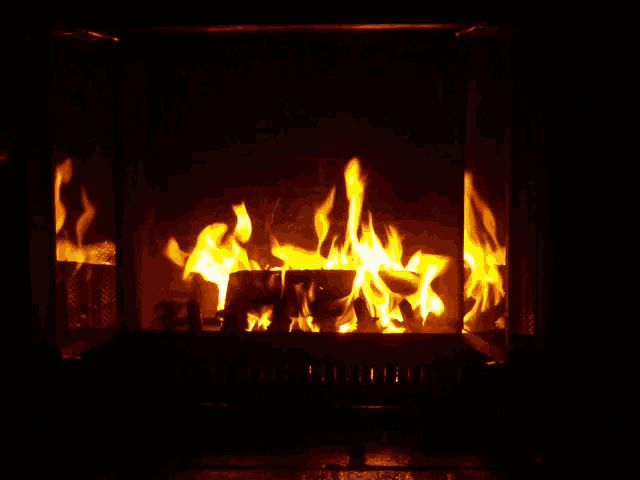 a fireplace with a lot of flames coming out of it and a black background