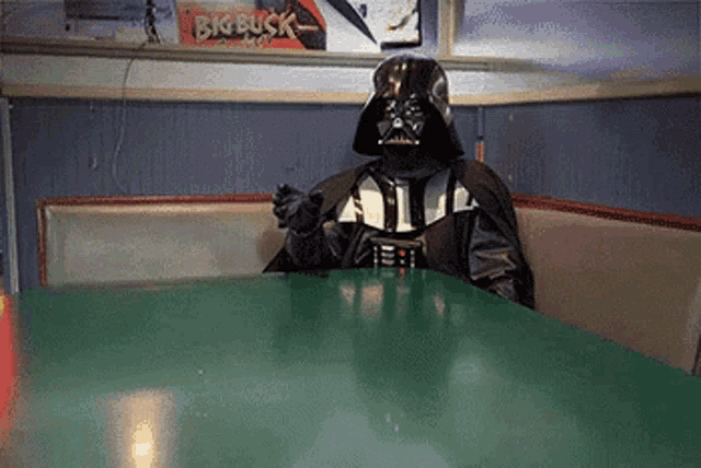 darth vader is sitting at a table in a diner