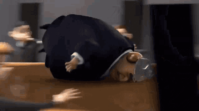 a cartoon of a man in a suit and hat laying on the floor .