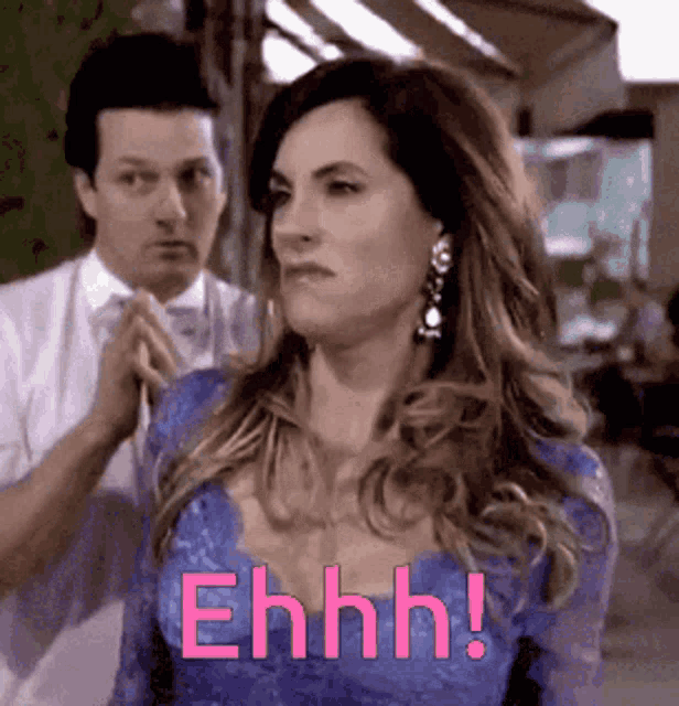 a woman in a blue dress says ehhh while standing next to a man