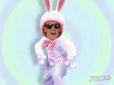 a man wearing a bunny costume and sunglasses is dancing .