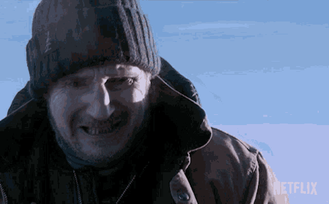 a close up of a man wearing a beanie and a jacket with a netflix logo in the corner