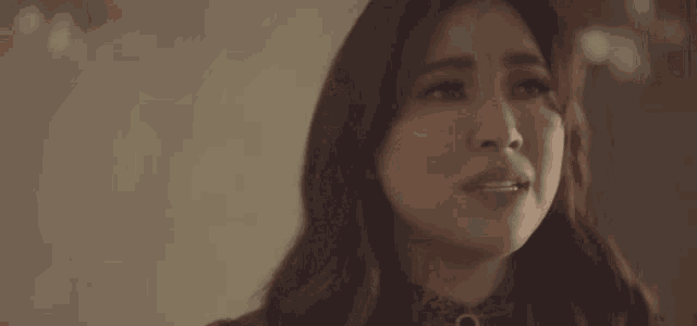 a close up of a woman 's face with a tear coming out of her eye .