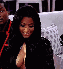 a woman with a plunging neckline is sitting next to a man and smiling .