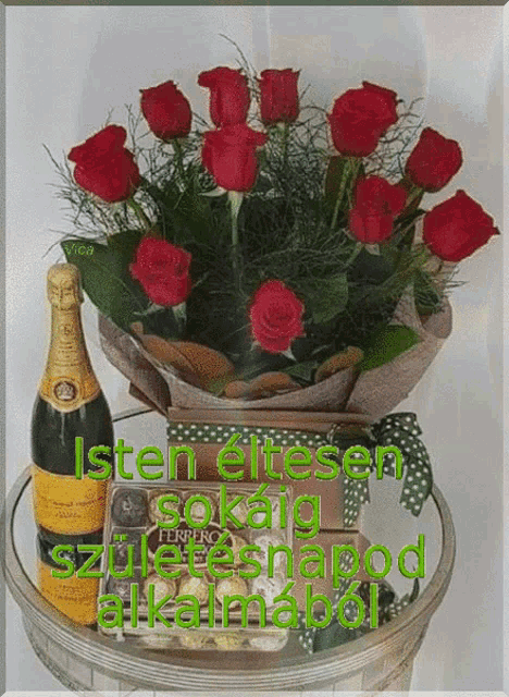 a bouquet of red roses sits on a table next to a bottle of ferrero chocolates