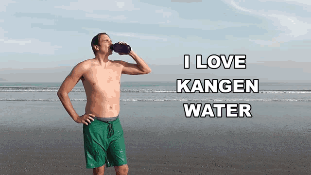 a shirtless man drinking from a bottle on the beach with the words " i love kangen water " behind him