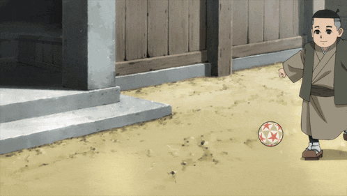 a boy in a kimono is kicking a ball