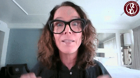 a woman wearing glasses and a black shirt with the letter s on her shirt