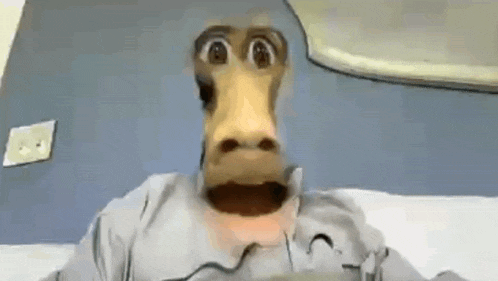 a cartoon monkey is sitting on a bed with his mouth open and looking at the camera .