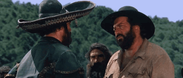 a man in a sombrero talks to another man