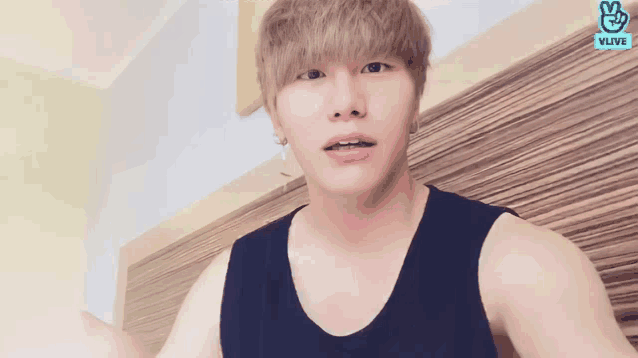 a young man is wearing a black tank top with vlive on the bottom