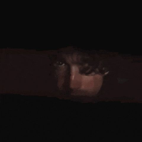 a close up of a man 's face in a dark room