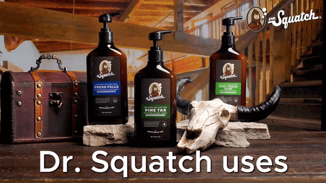 three bottles of dr. squatch lotion are on a wooden table