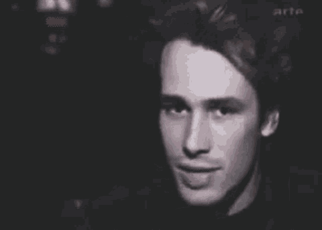 a close up of a man 's face with his hand waving