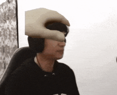 a person wearing headphones has a hand on their face