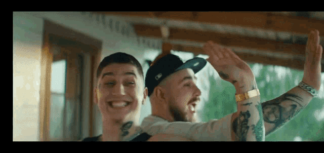 a man with a tattoo on his arm is holding another man