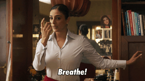 a woman wearing a white shirt says breathe