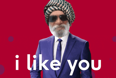 a man in a suit and tie is pointing at the camera with the words i like you below him