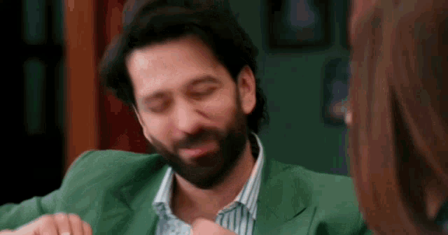 a man with a beard is sitting at a table with a woman .