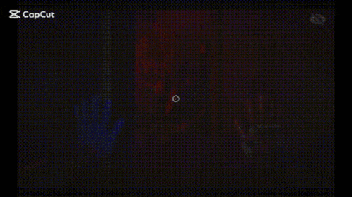 a person 's hand is visible in a dark room behind a screen .