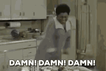a woman is standing in a kitchen and saying damn damn damn !