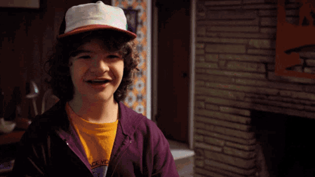 a young boy wearing a hat and a purple hoodie says i love you