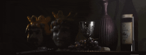 a bottle of wine sits on a shelf next to a wine cup
